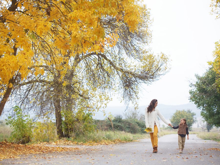 Mother and child walking in park.