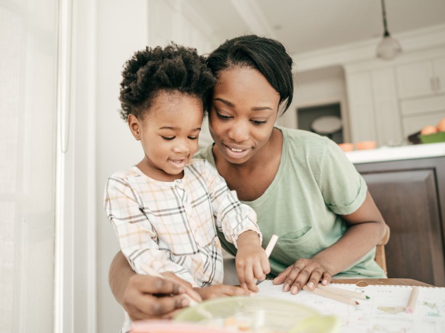 Mother and young daughter coloring together.