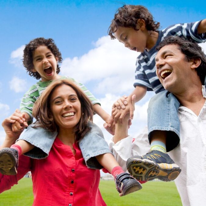 Online Course in Spanish Two parents and two children playing outside.