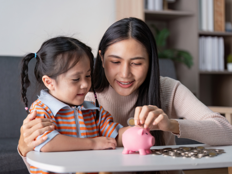 Mother and child counting money in a piggy bank