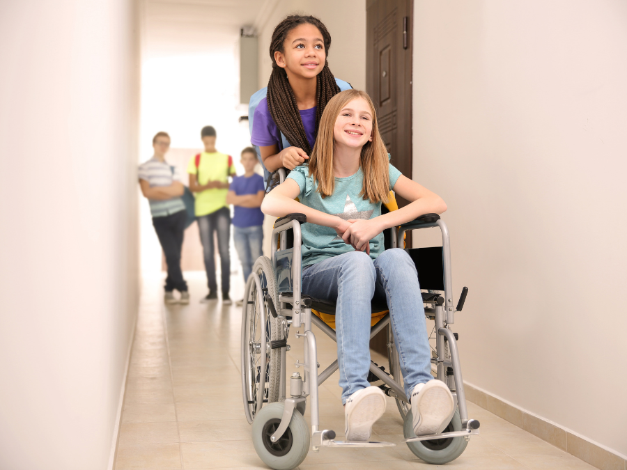A child pushing another child in a wheelchair